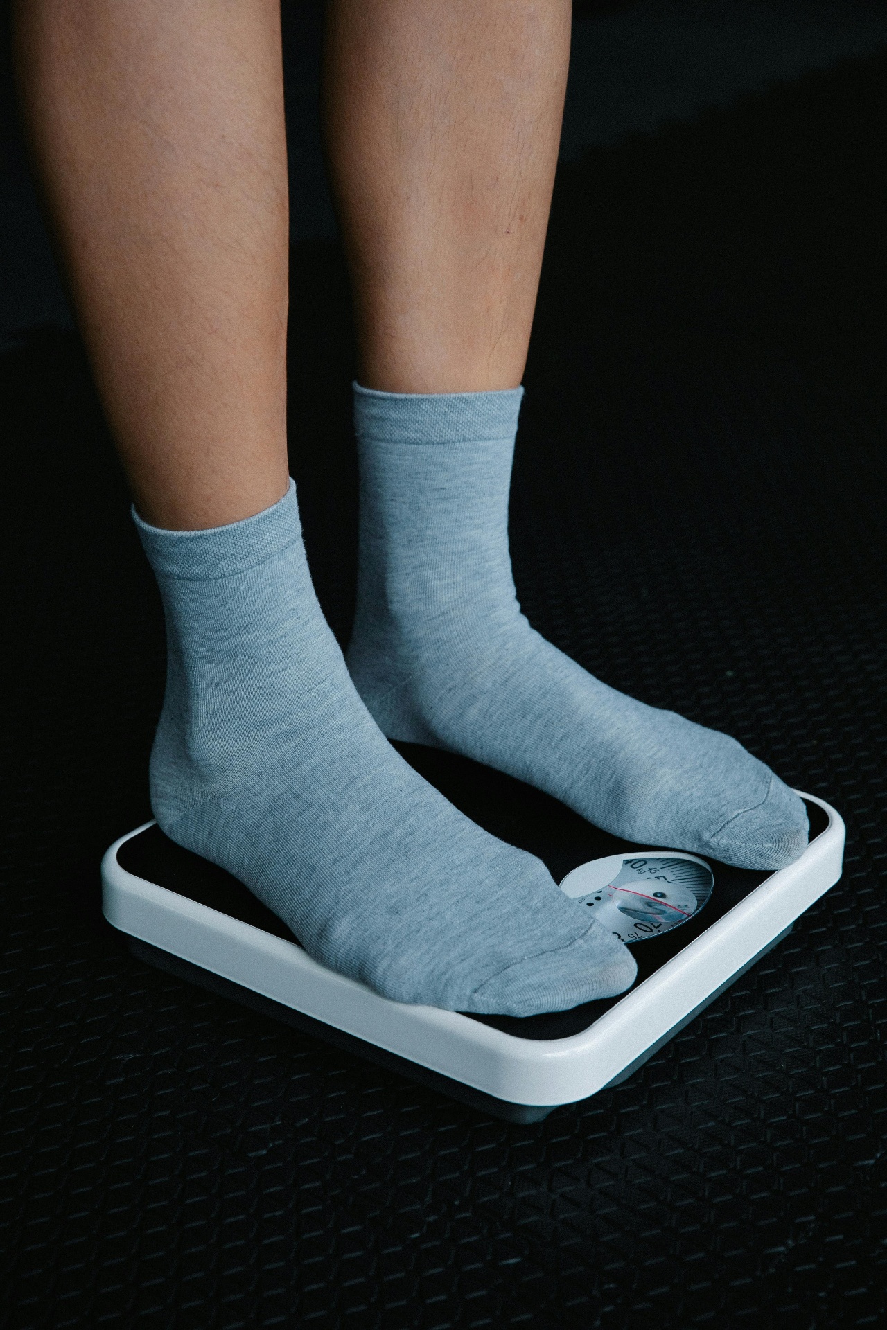 Personne sur une balance en chaussettes grises — bouillon d'os et perte de poids